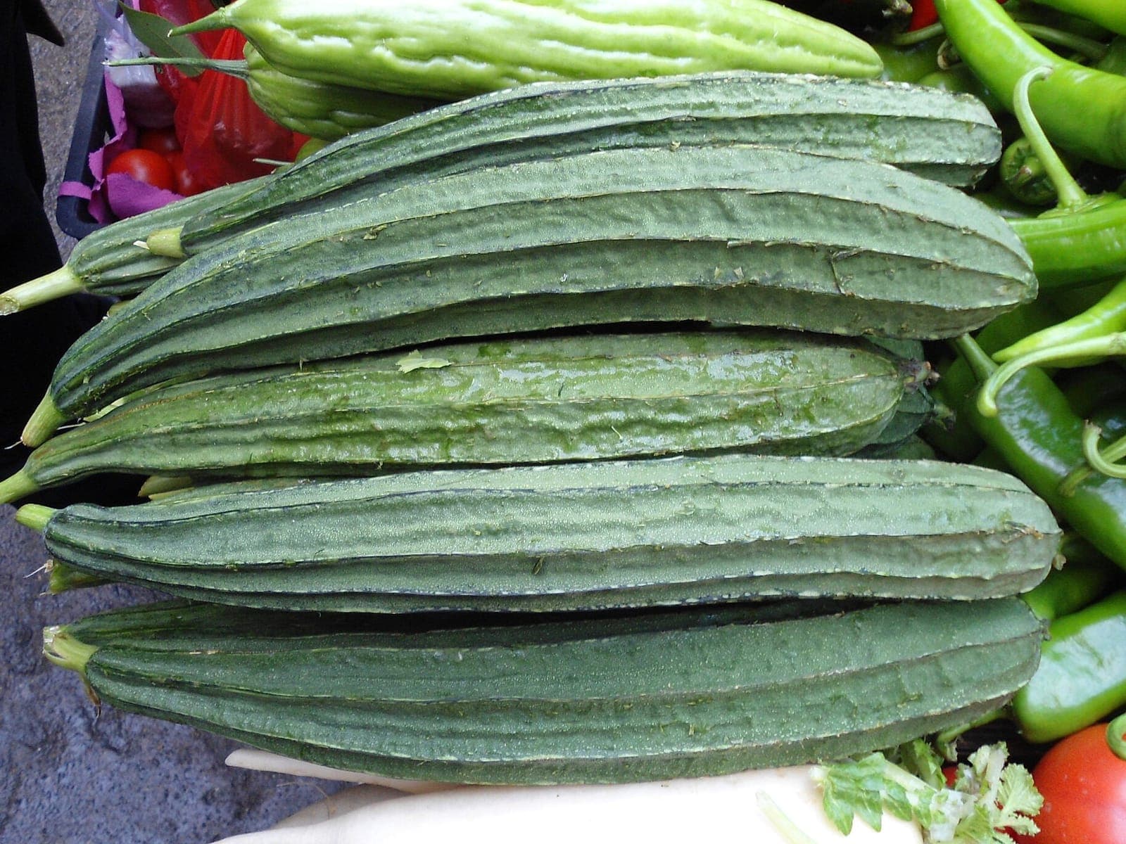 Fresh ridge gourds stacked at a vegetable market